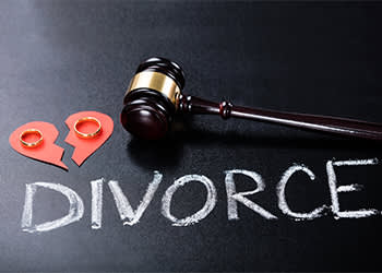 divorce word next to gavel and rings