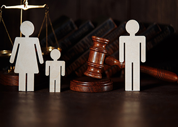 Paper cutouts of family next to a gavel
