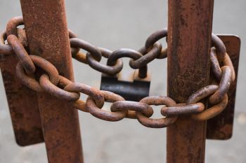 Rusted chain around two metal bars